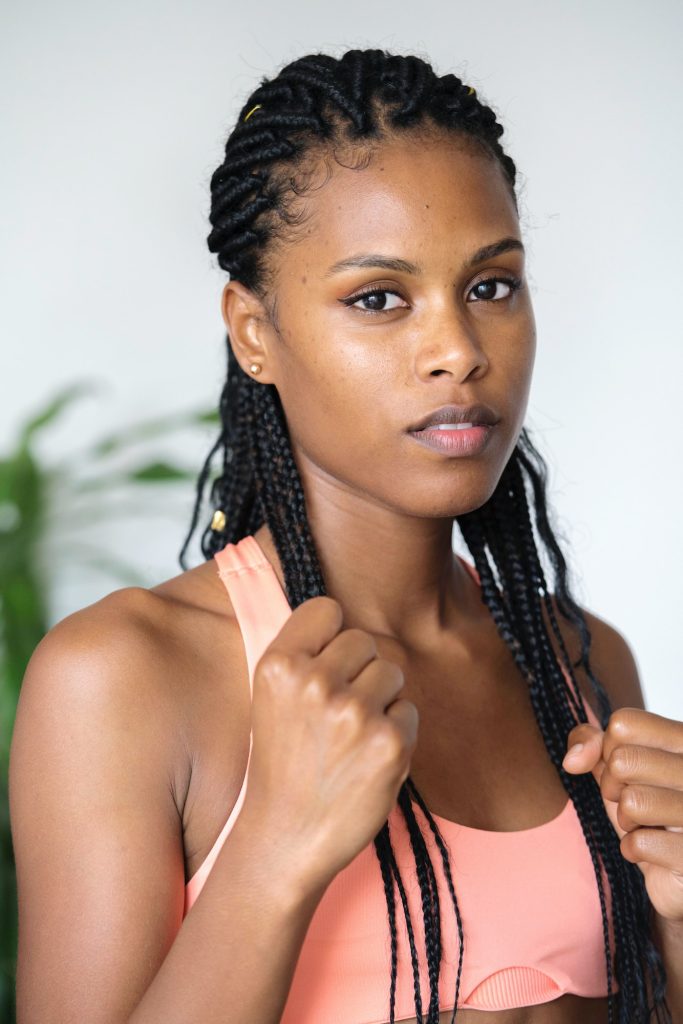 Black woman with braided hair in a boxing stance